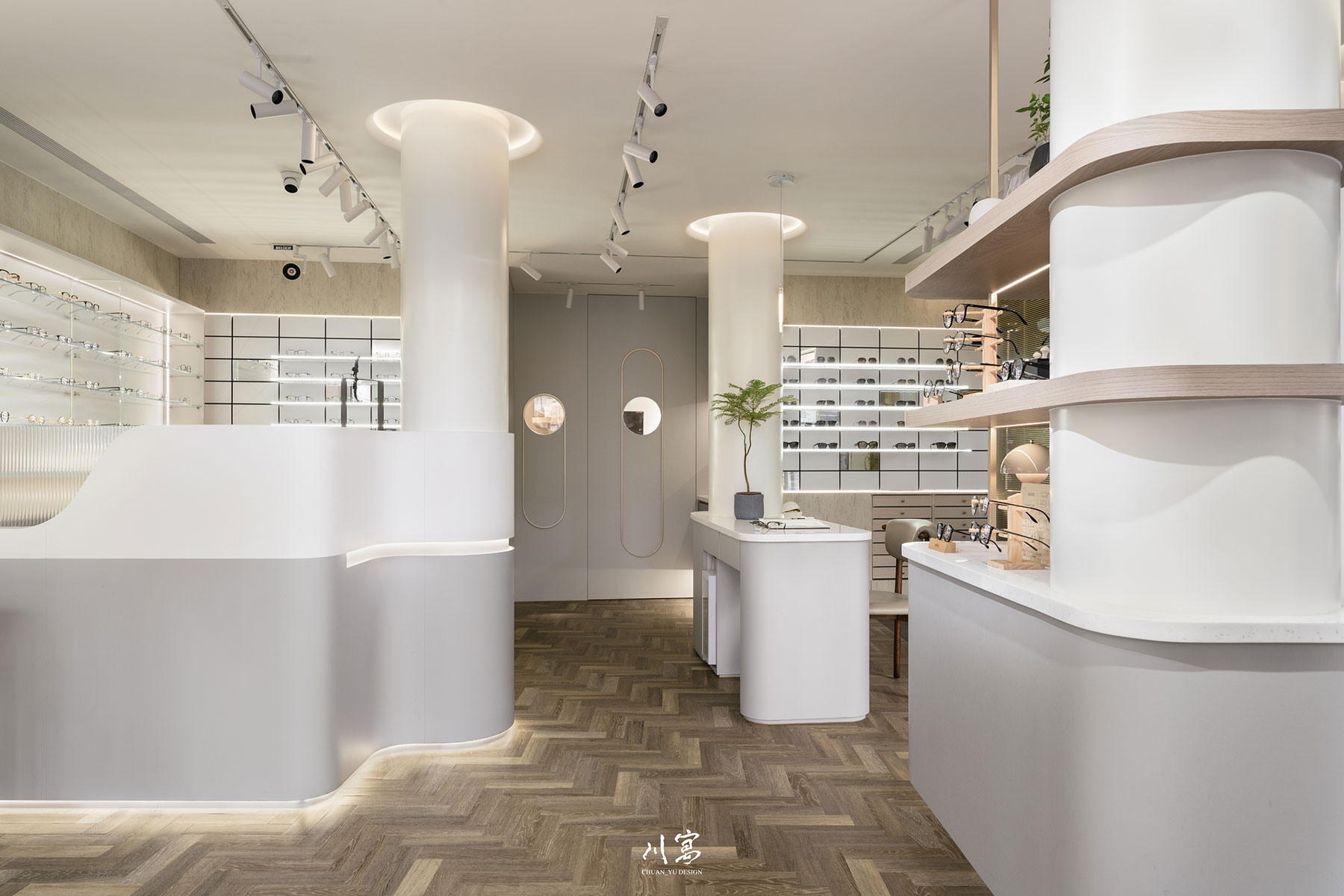 眼鏡行展示空間全景，大量弧形線條搭配暖灰與米色調，營造溫潤舒適的購物氛圍
