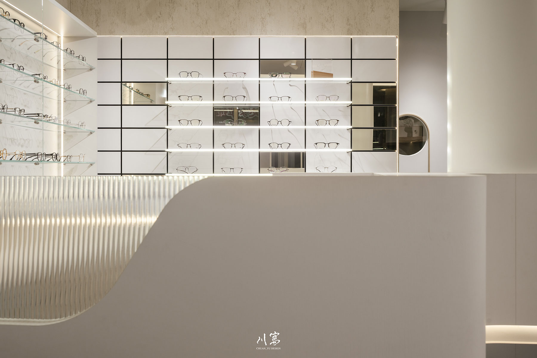 眼鏡行櫃檯細節，弧形玻璃設計與整面格狀展示牆形成視覺層次