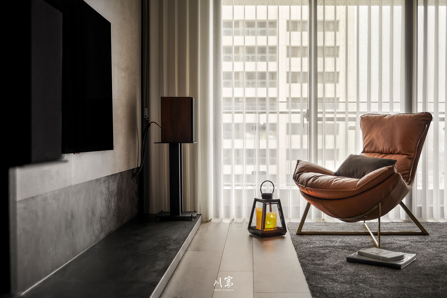 客廳橘色沙發單椅，成為空間視覺亮點，與灰黑基調形成對比